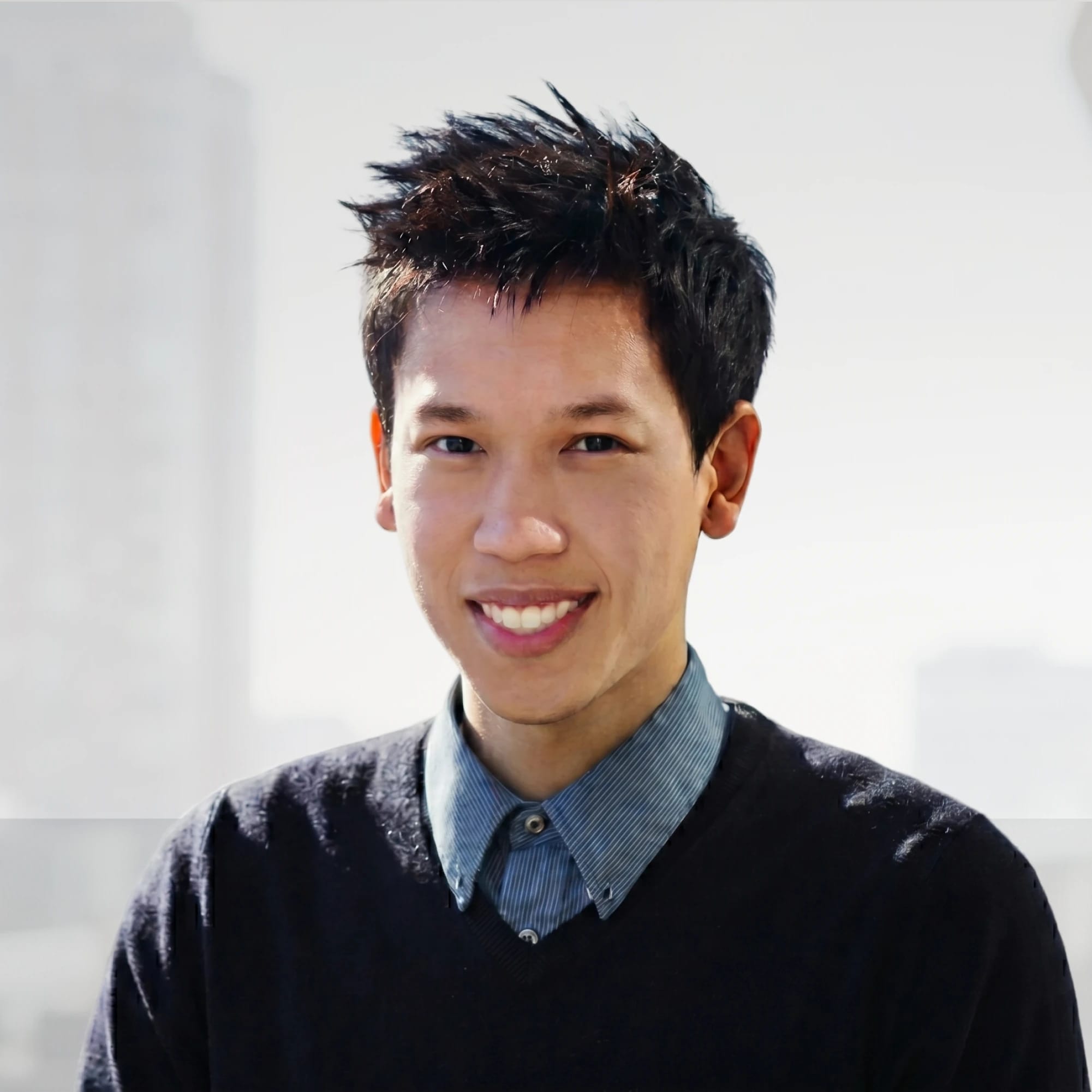 StoreFrame's founder smiling outdoors with a softly blurred city skyline behind him